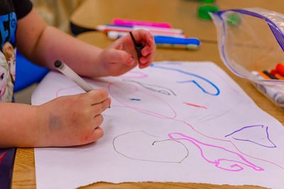 Child drawing on paper with markers